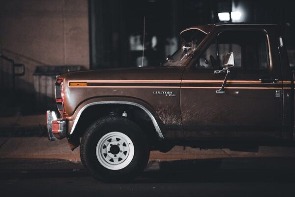 Classic Ford pickup truck parked on a city street at night, showcasing vintage style and nostalgia.