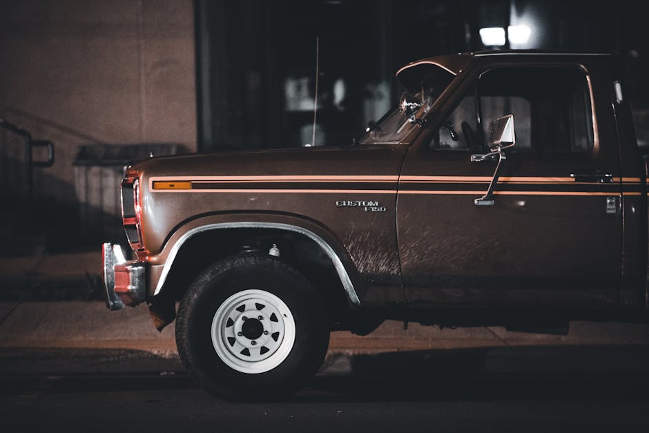 Classic Ford pickup truck parked on a city street at night, showcasing vintage style and nostalgia.
