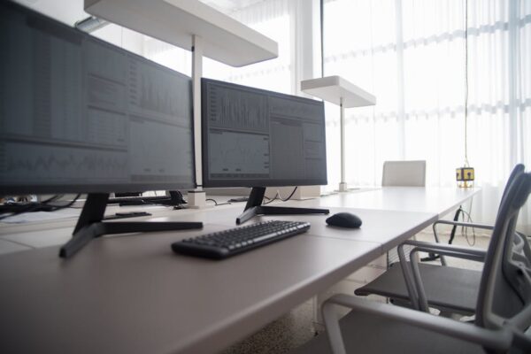Stylish contemporary office featuring multiple computer monitors and ergonomic chairs.