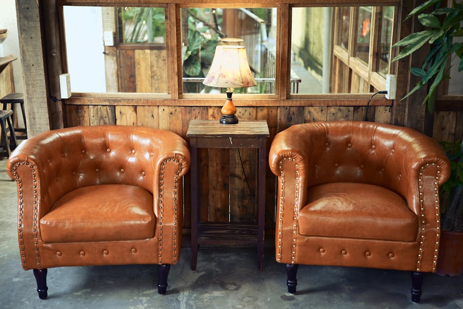Inviting rustic lounge setup with leather armchairs and a wooden lamp for a warm ambiance.