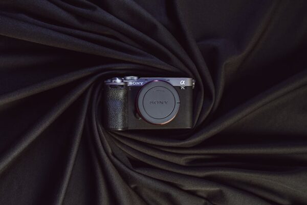 Stylish presentation of a modern mirrorless camera on elegant draped black fabric.