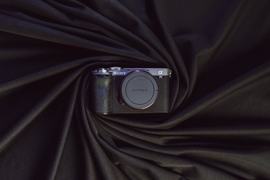 Stylish presentation of a modern mirrorless camera on elegant draped black fabric.