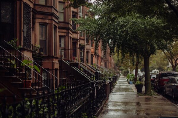 Quaint urban street view of brownstone homes on a rainy New York day.
